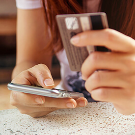 A person entering a credit card on a phone